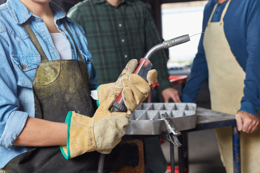 Arbeiterin hält ein Schweißgerät